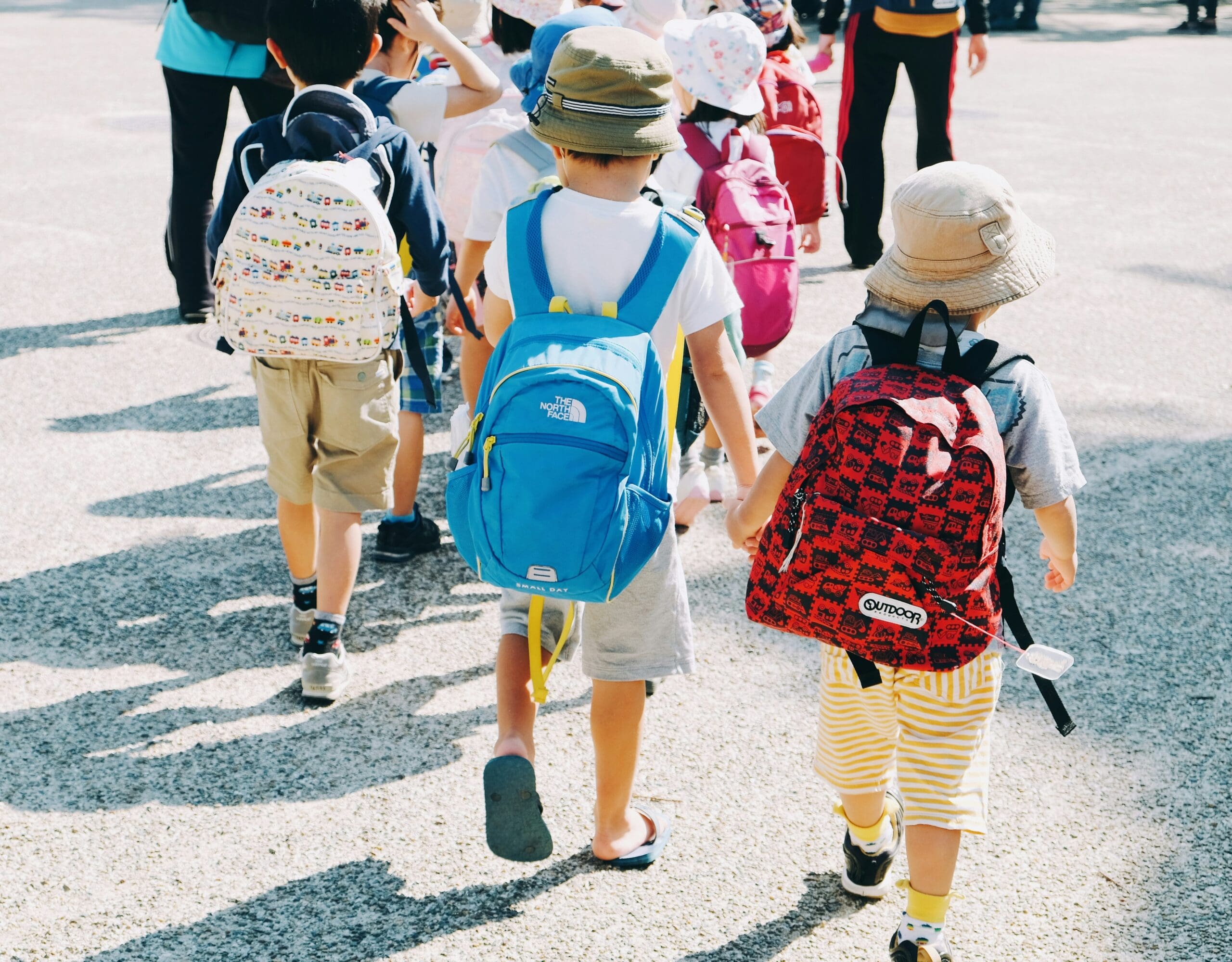 Students on a field trip walking while holding hands