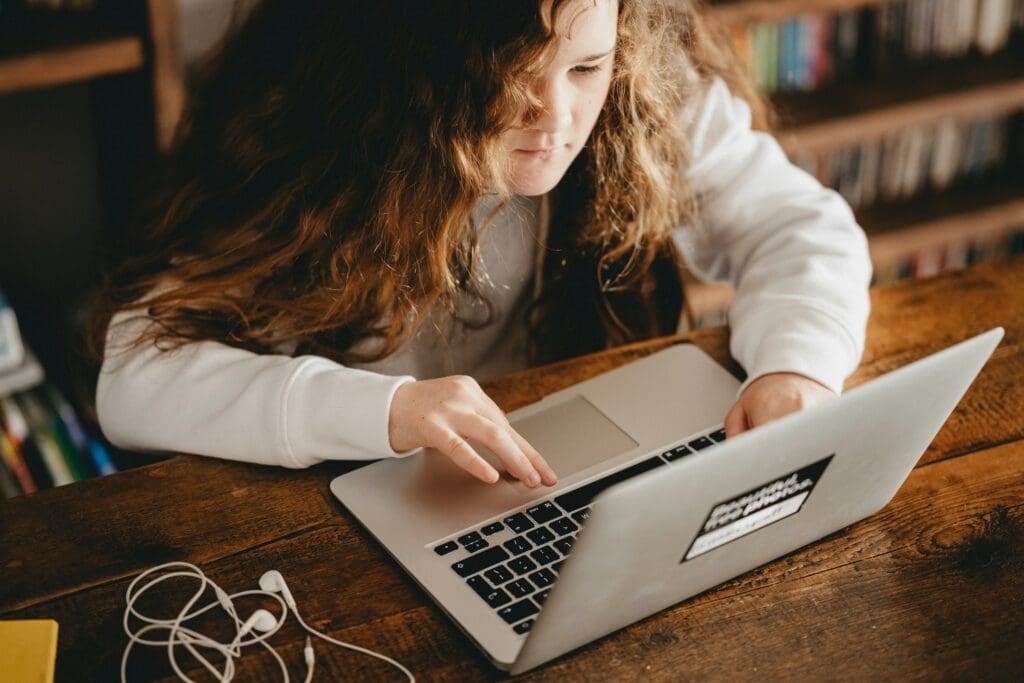 Student typing on a macbook